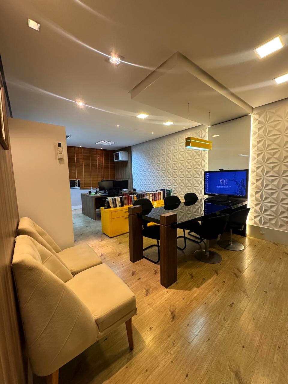 Visão ampla do escritório, com sala de reuniões e recepção
